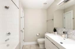 Unit 5 - Full bathroom with floating vanity and shower tub attached to bedroom 3 on the third (top) floor