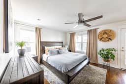 Unwind in Bedroom 1, the Master bedroom with ensuite bathroom, TV, and a comfy couch. Enjoy direct access to the second-floor balcony, complete with outdoor chairs for ultimate relaxation!