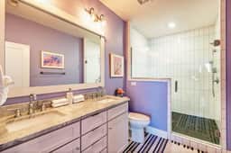 A roomy master bathroom, with everything you need, from a sleek walk-in shower to fluffy towels and double sinks.