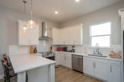 Welcome to kitchen perfection! Experience a clean, well-lit space equipped with high-end appliances for your cooking delight!