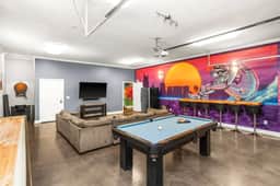 Movie nights, game nights, late nights. This room does it all with a big screen, bold mural, and plenty of seating.