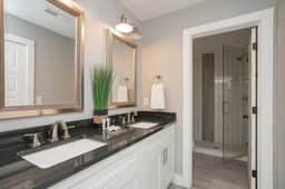 The en-suite bath offers his and her sinks, ensuring seamless mornings. Indulge in the spacious shower, creating a spa-like ambiance for rejuvenation. Unwind and refresh in style, where every day feels like a getaway!