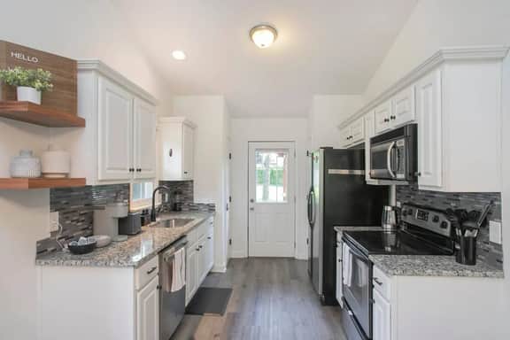 Our clean and spacious kitchen! Fully equipped with modern appliances and everything you need to cook up a feast, it's perfect for preparing meals and gathering with loved ones.