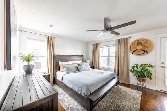 Unwind in Bedroom 1, the Master bedroom with ensuite bathroom, TV, and a comfy couch. Enjoy direct access to the second-floor balcony, complete with outdoor chairs for ultimate relaxation!