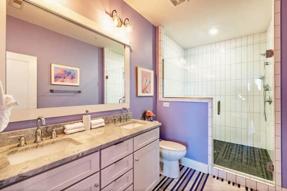 A roomy master bathroom, with everything you need, from a sleek walk-in shower to fluffy towels and double sinks.