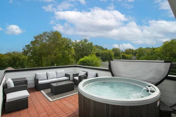 This stunning rooftop boasts a hot tub and outdoor furniture, perfect for relaxing and taking in gorgeous city views while reminiscing about your Nashville adventures!
